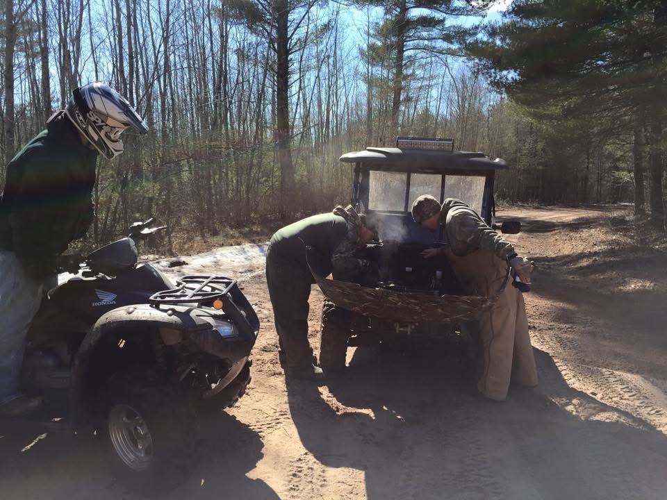 ATV riders in forest clearing