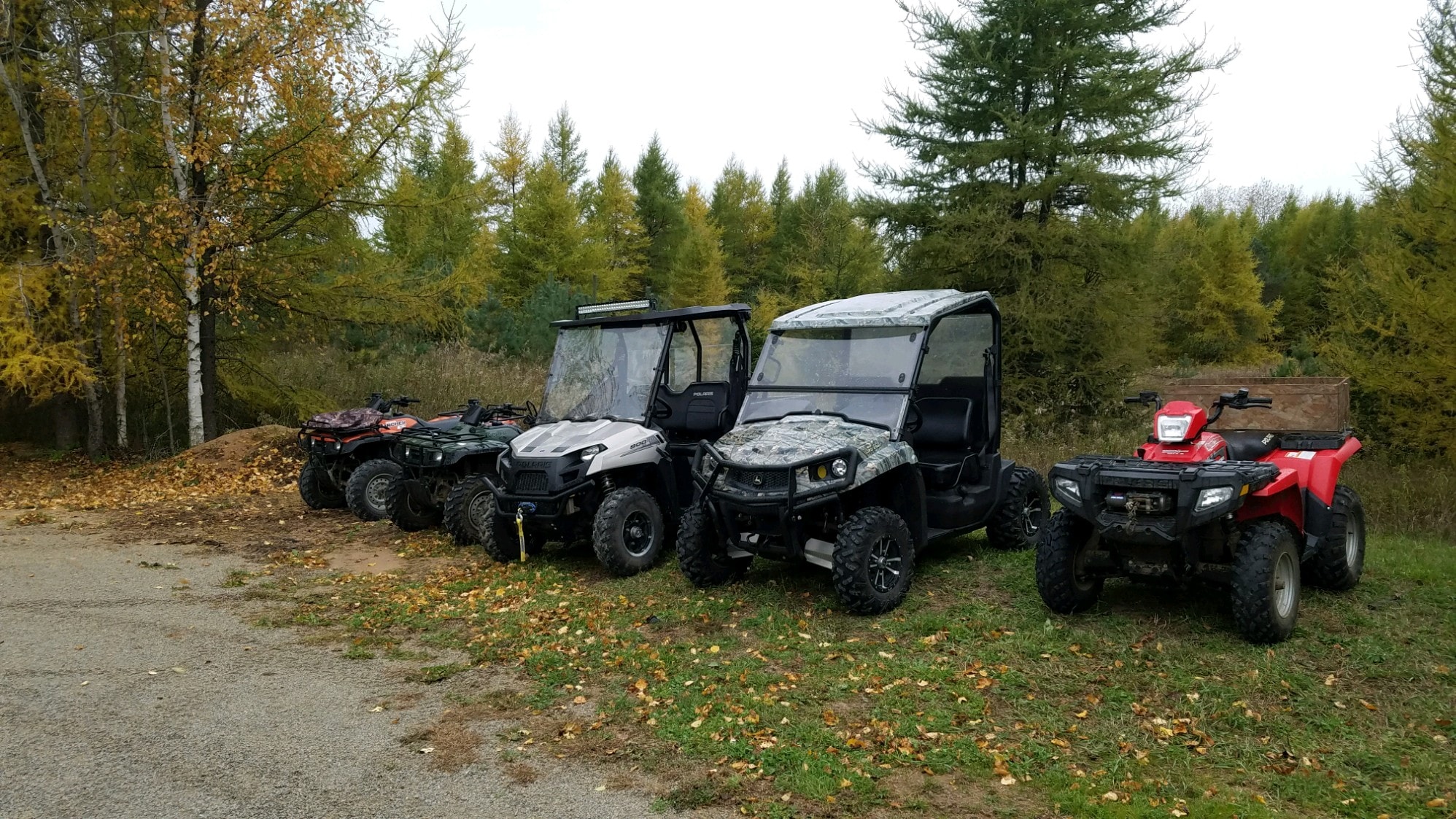 ATVs and utility vehicles parked in forest